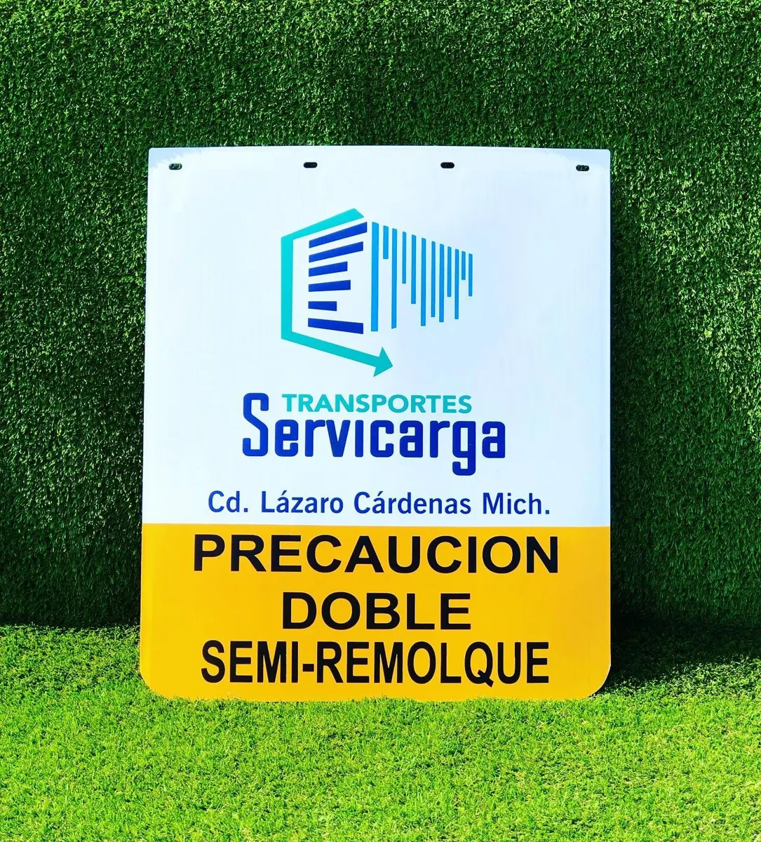 Lodera blanca con logotipo de transportista y franja amarilla con la leyenda Precaución doble semirremolque