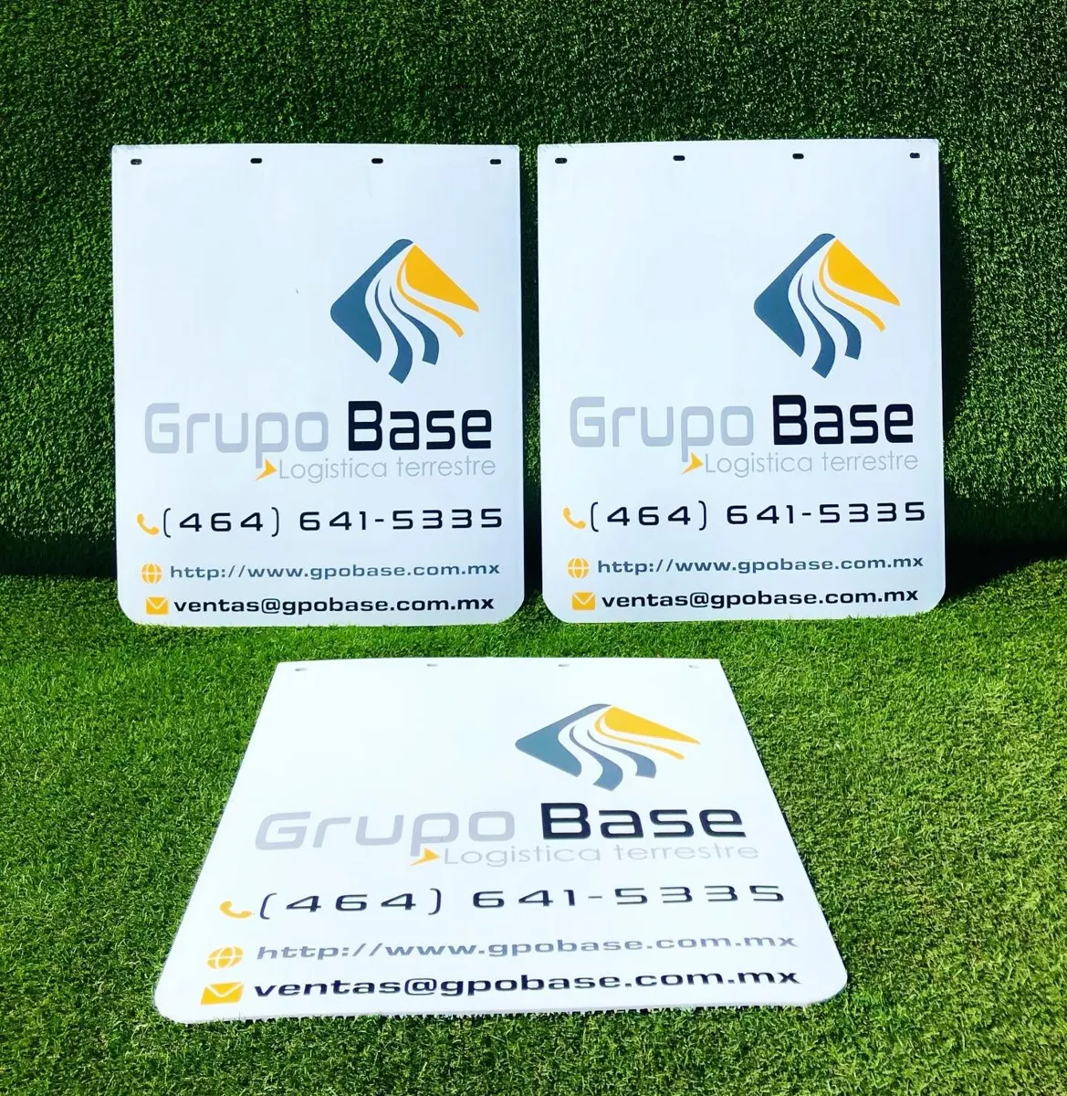 Tres loderas blancas idénticas con el logotipo, teléfono, página web y correo de una empresa de logística terrestre